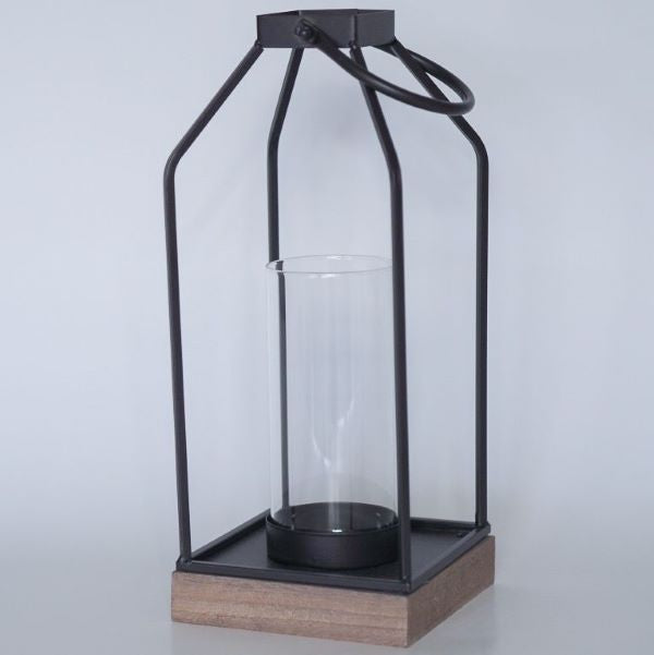 Tyylikkäät mustat lyhdyt puisella pohjalla. Sivut ovat aukinaiset ja sisälle mahtuu halkasijaltaan 10 cm kynttilä.