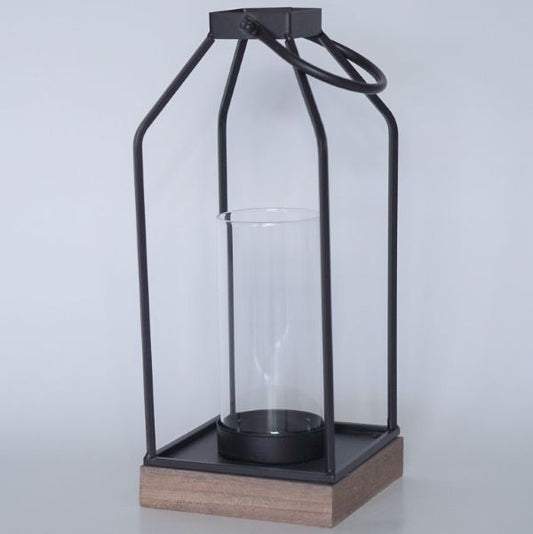 Tyylikkäät mustat lyhdyt puisella pohjalla. Sivut ovat aukinaiset ja sisälle mahtuu halkasijaltaan 10 cm kynttilä.