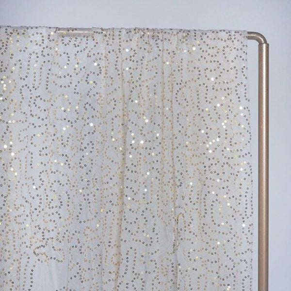 Läpikuultava vaalea kangas kultaisilla paljettikuvioilla