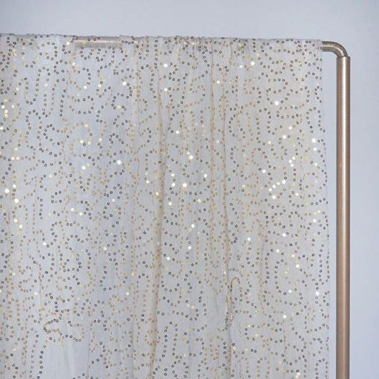 Läpikuultava vaalea kangas kultaisilla paljettikuvioilla