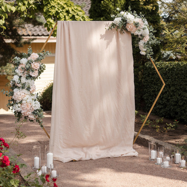 Näyttävä kullanvärinen hexagon somistettuna kankailla ja kukilla.