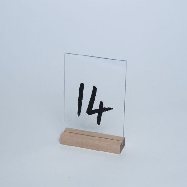 Upeat pöytänumerot, joissa musta numerointi. Nämä tyylikkäät pöytänumerot sisältävät kuvassa näkyvän puisen pidikkeen. Puisen pidikkeen avulla ne seisovat tukevasti pöydällä. Numerot 1-12.